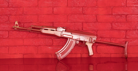 red Kalashnikov assault rifle on a red table