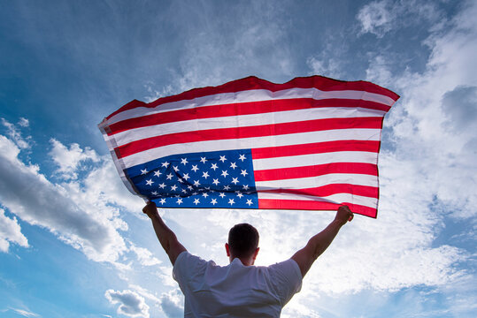 Man holding waving American USA flag in hands in USA, concept picture