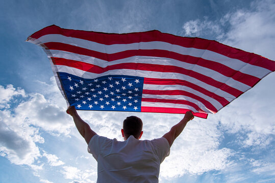 Man holding waving American USA flag in hands in USA, concept picture