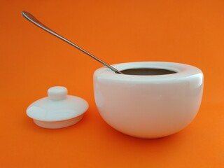 
beautiful white sugar bowl with an orange background