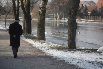 zimowy spacer promenadą wzdłuż rzeki - obrazy, fototapety, plakaty