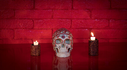 sugar skull on red table, red brick wall background