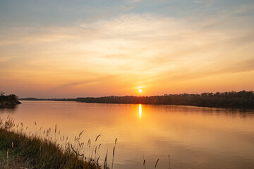 Fototapeta na wymiar Beautiful sunset on the banks of a large river
