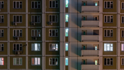 Facade of an apartment building with luminous windows at night