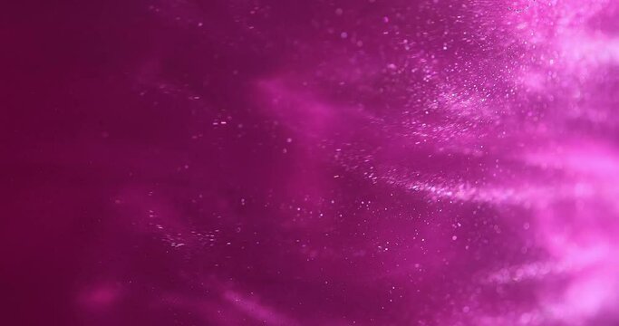 Pink glittery paint creating abstract clouds. Art backgrounds. Fuchsia color fluid is swirling in beautiful silver clouds. Glitter dust is moving slowly in water. Amazing abstract texture background