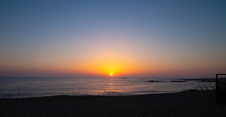 Sunset over the ocean in summer on the beach with vivid gradient sky.