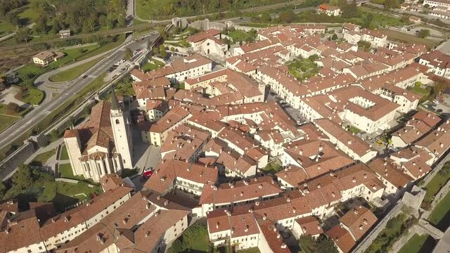 Top down aerial view of a small historic town Venzone in Northern Italy with red tiled roofs of old buildings.