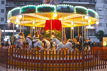 Carousel in Christmas time with children riding the horses