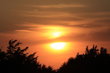 Colorful Sunset with tree Silhouettes and clouds out in the country in Kansas.