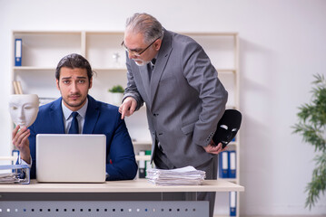 Old boss and young male employee wearing masks