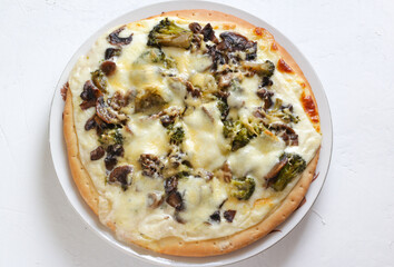 Vegetarian pizza with broccolli and mushrooms on the table white background. Copy space. Top view