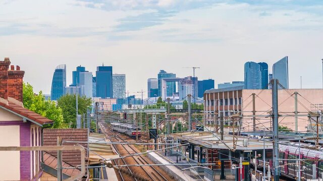 4k timelapse of skyscrapers of Paris business district La Defense on a cloudy summer day and the RER train station. From houilles, west of Paris, France.Camera zooms in