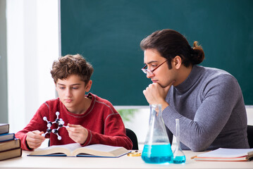 Young male teacher and schoolboy in the classroom