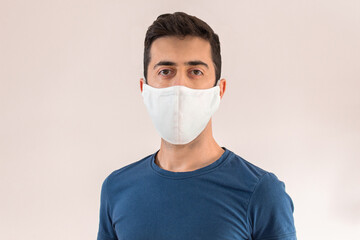 Young man using a mask to cover his mouth and nose to have protection from the global coronavirus pandemic