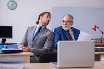 Fototapeta premium Two male employees working in the office