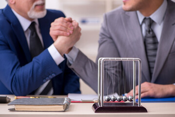 Two businessmen and meditation balls on the table