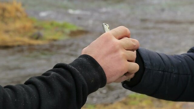 A man pulls the grenade ring, another man grabs his hand instantly