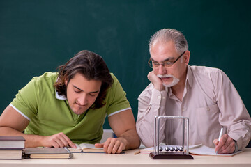 Old professor physicist and young student in the classroom
