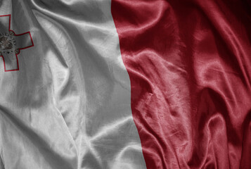 colorful shining big national flag of malta on a silky texture.