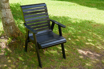 A wooden brown chair outdoor on the grass. Copy space.