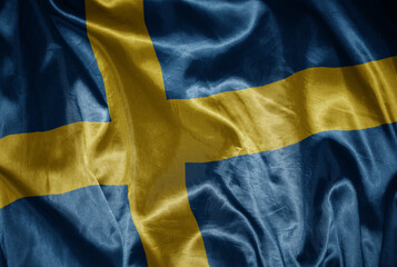 colorful shining big national flag of sweden on a silky texture.