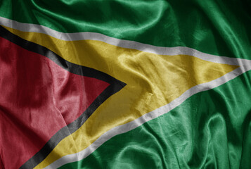 colorful shining big national flag of guyana on a silky texture.