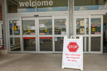 Stop sign at entrance to store requiring face masks before entering