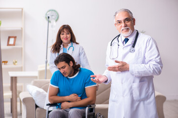 Obraz premium Two doctors visiting sick young man at home