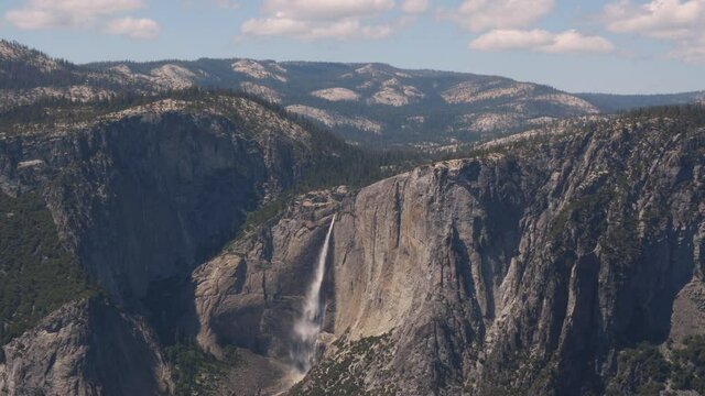 Wide open view of waterfall, mountains, and valley in Yosemite National Park.