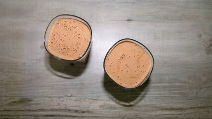 Top view of two glasses with chocolate favor protein shakes.