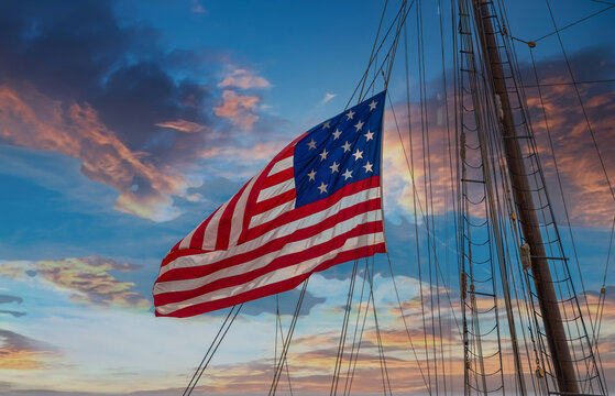 An American flag flying from the riggings of a tall ship