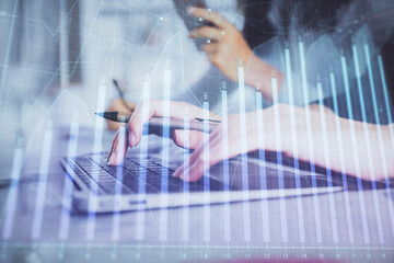 Multi exposure of woman hands typing on computer and financial graph hologram drawing. Stock market analysis concept.