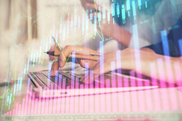 Multi exposure of woman hands typing on computer and financial graph hologram drawing. Stock market...