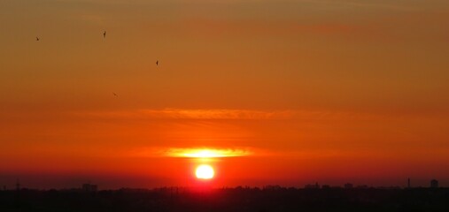 Panoramic view of beautiful fiery orange sunset background over the city