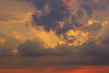 Naklejka na ściany i meble Beautiful orange sunset with dark dramatic clouds in the sky, natural background