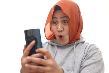 Successful muslim Asian woman surprised amazed smiling while reading message text good news on her smart phone