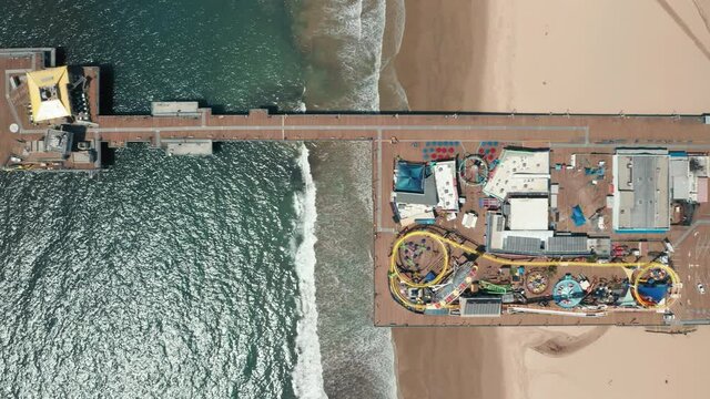 Colorful Roller Coasters On The Pier With The Scenic Ocean View. 4K Overhead Drone View On Closed Attraction Park During COVID-19 Pandemic And Quarantine In Los Angeles, California USA. 