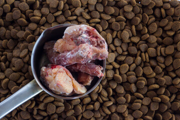 Dry,adult dog food with vitamin and uncooked chicken.Above view,background.