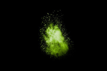 Abstract green dust explosion on black background. Green powder splattered.
