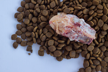 Dry,adult dog food with vitamin and uncooked chicken.Above view,background.