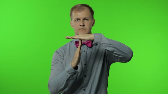 Man showing time out sign. This is limit, enough gesture. Portrait of guy on chroma key background