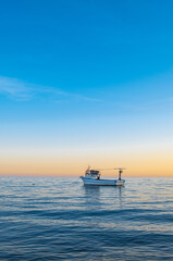 fishing boat and sunset on calm sea
