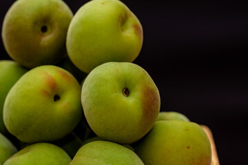 Harvested Green Japanese apricot fruit, Young fruits of Ume, Black background