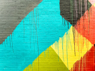 Brick wall splashed with gray, blue, black, yellow, orange, red and lime green colors - obrazy, fototapety, plakaty