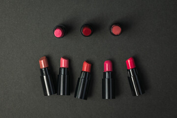 Several samples of lipstick on a black background.