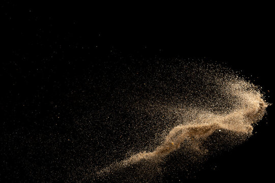 Gold sand explosion isolated on black background. 
