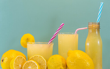 Fototapeta premium Refreshing drink of lemonade and lemons on green background