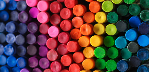 Box of crayons in a rainbow of colors background