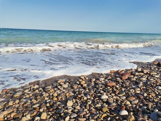 Fototapeta na wymiar Stone beach and turquoise sea