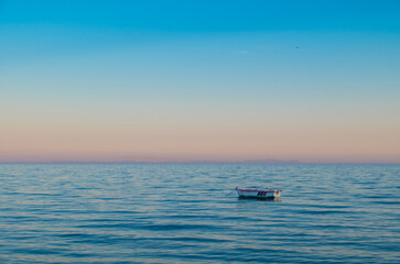 fishing boat and sunset on calm sea, tranquil background,